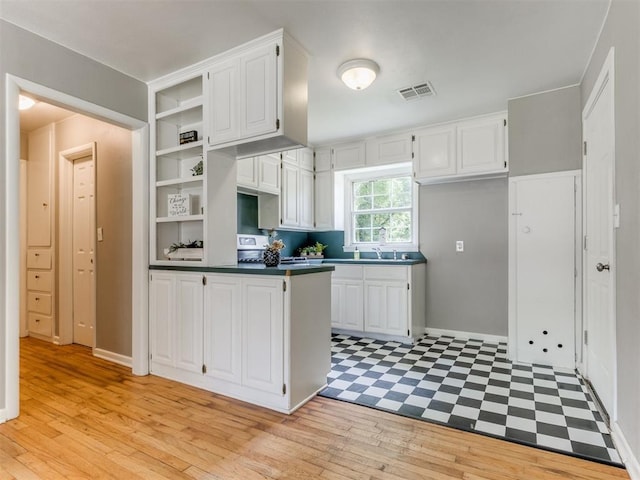 1125 E Fay St, Shawnee, OK 74801 - kitchen with open shelves, white cabinetry, dark countertops, and a peninsula