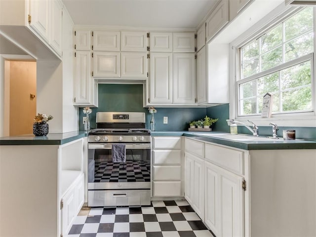 1125 E Fay St, Shawnee, OK 74801 - kitchen with stainless steel gas range oven, tile patterned floors, and white cabinetry