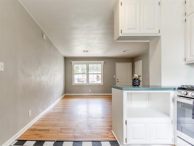 1125 E Fay St, Shawnee, OK 74801 - kitchen featuring gas range, light wood-type flooring, white cabinetry, and open floor plan