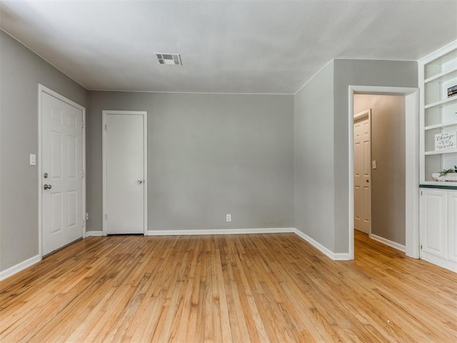 1125 E Fay St, Shawnee, OK 74801 - empty room featuring light wood-type flooring and built in shelves