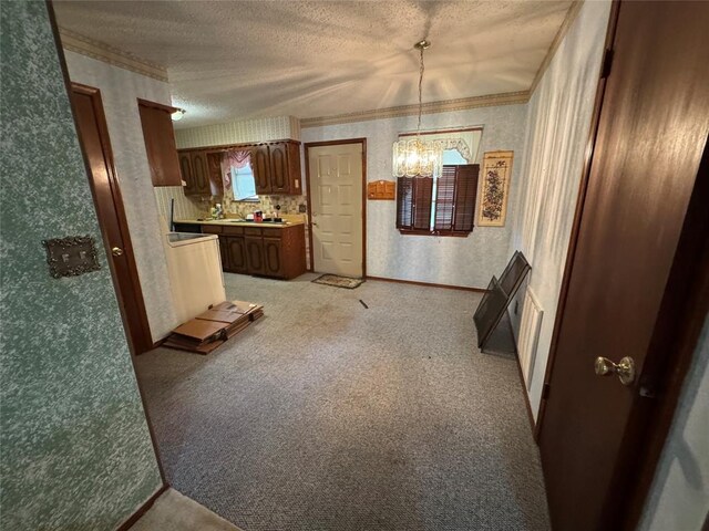 1217 Dove Hollow Dr, Tecumseh, OK 74873 - kitchen featuring wallpapered walls, a textured ceiling, a chandelier, light countertops, and crown molding