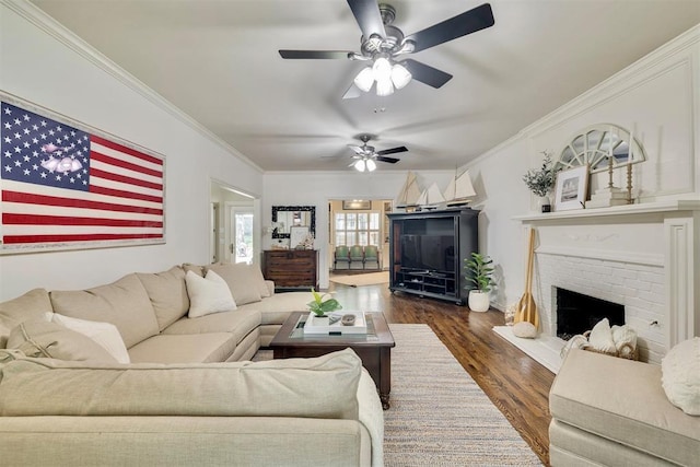 4201 Echohollow Trl, Edmond, OK 73025 - living room featuring dark wood-type flooring, crown molding, a ceiling fan, and a brick fireplace