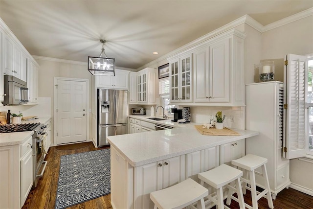 4201 Echohollow Trl, Edmond, OK 73025 - kitchen with appliances with stainless steel finishes, a peninsula, dark wood-style floors, glass insert cabinets, and crown molding
