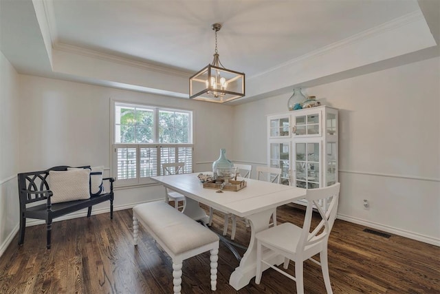 4201 Echohollow Trl, Edmond, OK 73025 - dining area with a chandelier, a tray ceiling, dark wood-style flooring, and crown molding