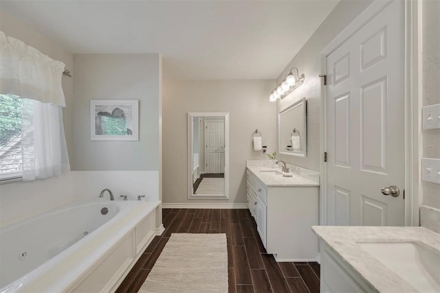 4201 Echohollow Trl, Edmond, OK 73025 - bathroom featuring two vanities, wood finish floors, and a whirlpool tub