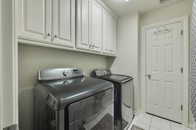 4201 Echohollow Trl, Edmond, OK 73025 - laundry area featuring separate washer and dryer, cabinet space, and light tile patterned floors