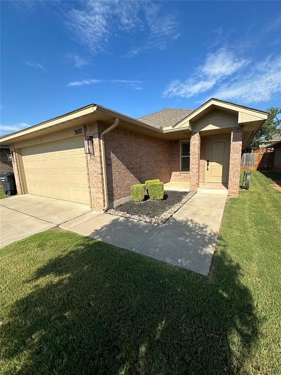 3600 Green Apple Pl, Moore, OK 73160 - single story home with brick siding, a garage, and driveway