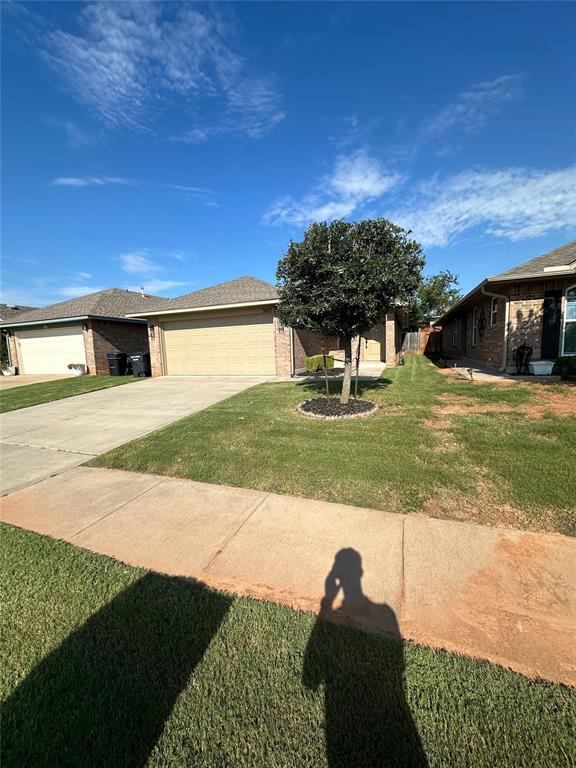 3600 Green Apple Pl, Moore, OK 73160 - view of front of house with driveway, an attached garage, a front lawn, and brick siding