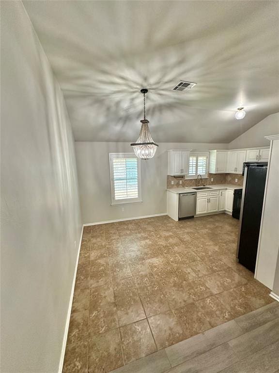 3600 Green Apple Pl, Moore, OK 73160 - kitchen featuring dishwasher, healthy amount of natural light, vaulted ceiling, white cabinetry, and freestanding refrigerator