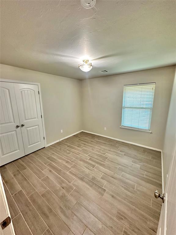 3600 Green Apple Pl, Moore, OK 73160 - unfurnished bedroom featuring wood finished floors and a closet