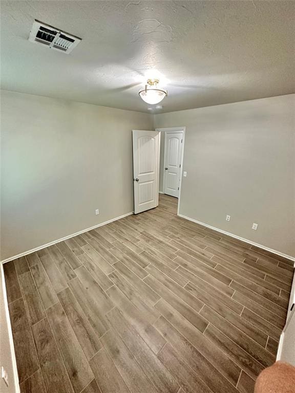 3600 Green Apple Pl, Moore, OK 73160 - empty room with wood finished floors and a textured ceiling
