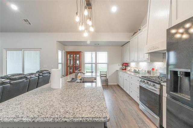 3356 E Maple Rd, Purcell, OK 73080 - kitchen with stainless steel appliances, premium range hood, light wood-type flooring, white cabinets, and decorative backsplash