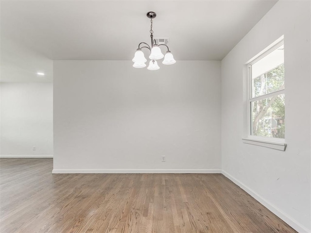 1420 SW 67th St, Oklahoma City, OK 73159 - spare room featuring wood finished floors and a chandelier