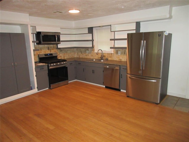404 S 6th St, Tecumseh, OK 74873 - kitchen with appliances with stainless steel finishes, decorative backsplash, and light wood-type flooring