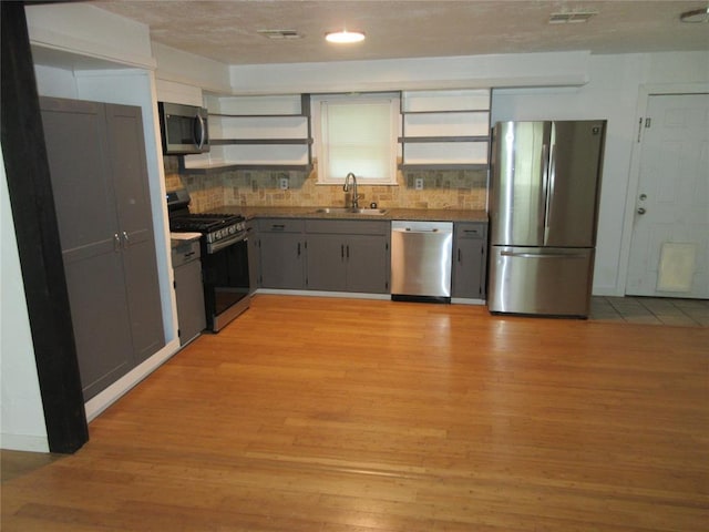 404 S 6th St, Tecumseh, OK 74873 - kitchen featuring stainless steel appliances, open shelves, and light wood-style floors