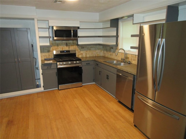 404 S 6th St, Tecumseh, OK 74873 - kitchen featuring appliances with stainless steel finishes, open shelves, decorative backsplash, and light wood-style floors