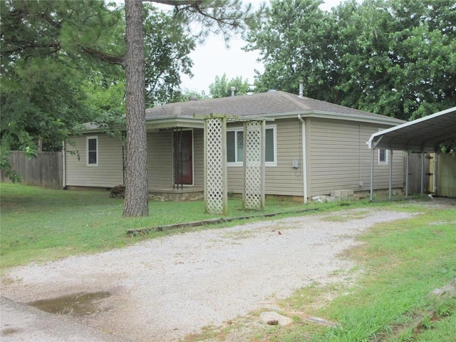 404 S 6th St, Tecumseh, OK 74873 - view of front facade with driveway, a detached carport, and a shingled roof
