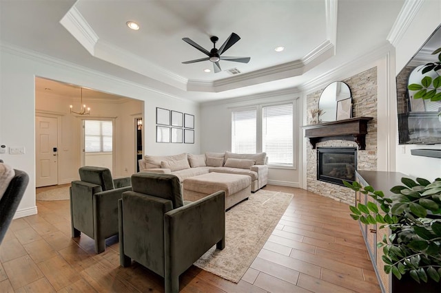 15728 Egerton Pl, Edmond, OK 73013 - living area with a raised ceiling, a ceiling fan, a fireplace, hardwood / wood-style flooring, and ornamental molding