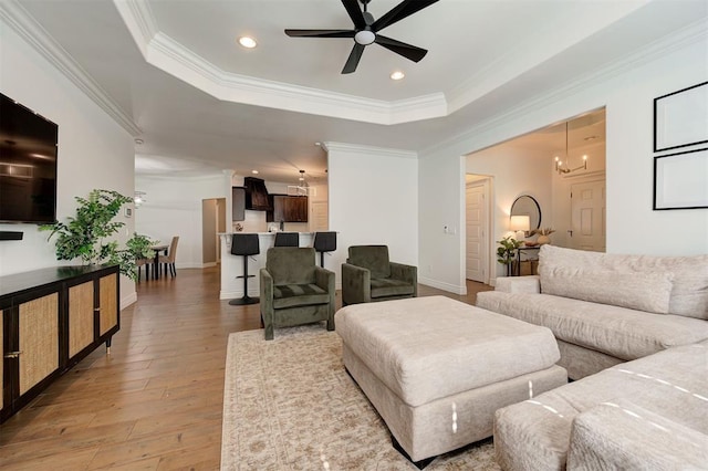 15728 Egerton Pl, Edmond, OK 73013 - living area with a ceiling fan, a raised ceiling, crown molding, light wood-style flooring, and recessed lighting