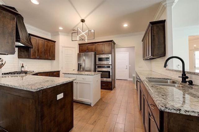 15728 Egerton Pl, Edmond, OK 73013 - kitchen with a peninsula, dark brown cabinetry, light stone counters, appliances with stainless steel finishes, and backsplash