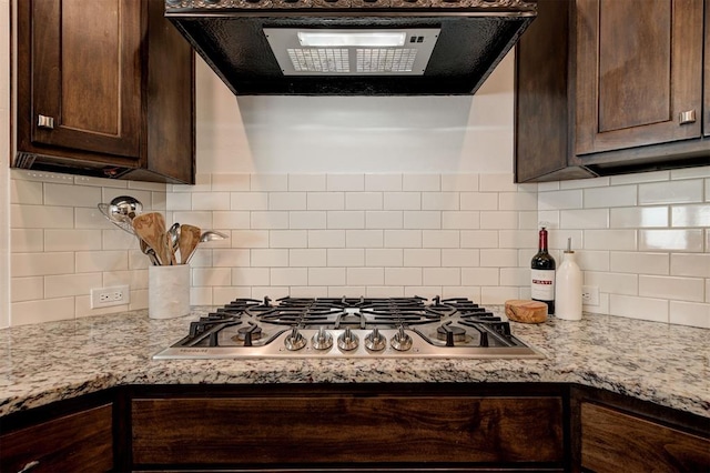 15728 Egerton Pl, Edmond, OK 73013 - kitchen with extractor fan, dark brown cabinetry, stainless steel gas cooktop, backsplash, and light stone counters