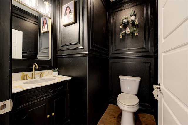15728 Egerton Pl, Edmond, OK 73013 - bathroom featuring vanity, a decorative wall, and wood finished floors