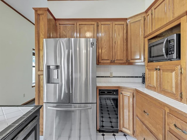 18317 Chestnut Oak Dr, Edmond, OK 73012 - kitchen with appliances with stainless steel finishes, tile countertops, backsplash, and brown cabinets