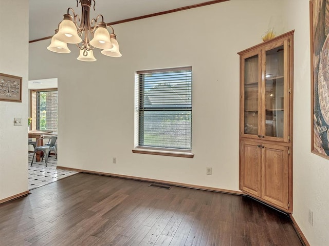 18317 Chestnut Oak Dr, Edmond, OK 73012 - unfurnished dining area with a chandelier, dark wood finished floors, and crown molding