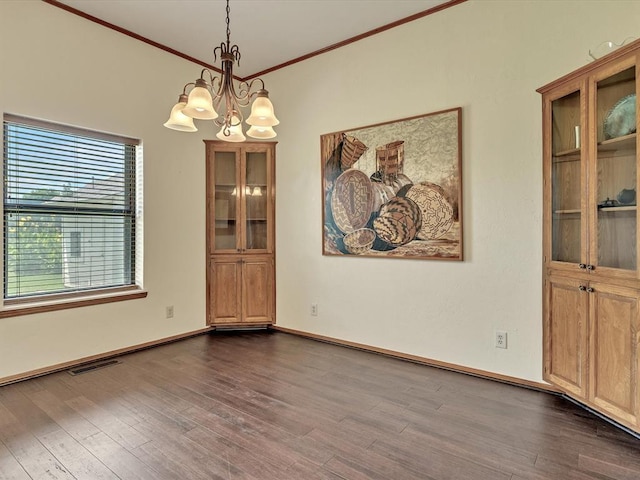 18317 Chestnut Oak Dr, Edmond, OK 73012 - unfurnished dining area featuring dark wood finished floors, a chandelier, and crown molding