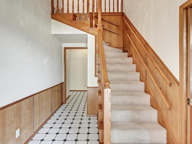 18317 Chestnut Oak Dr, Edmond, OK 73012 - stairs with tile patterned floors, wainscoting, and wood walls