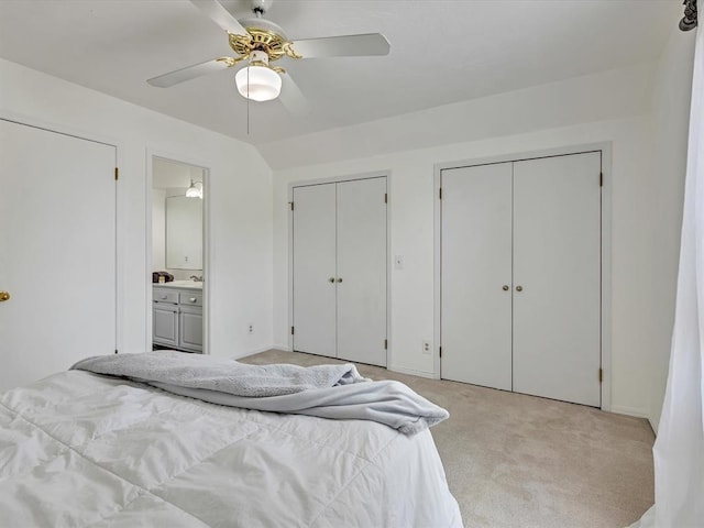 18317 Chestnut Oak Dr, Edmond, OK 73012 - bedroom with multiple closets, light colored carpet, connected bathroom, and a ceiling fan