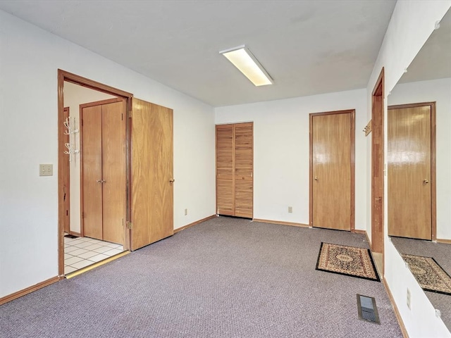18317 Chestnut Oak Dr, Edmond, OK 73012 - unfurnished bedroom featuring multiple closets and light colored carpet