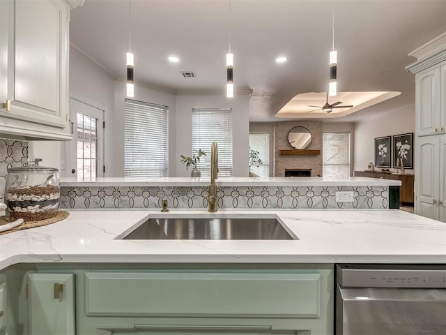 1340 NW 168th St, Edmond, OK 73012 - kitchen with stainless steel dishwasher, a ceiling fan, open floor plan, a fireplace, and hanging light fixtures
