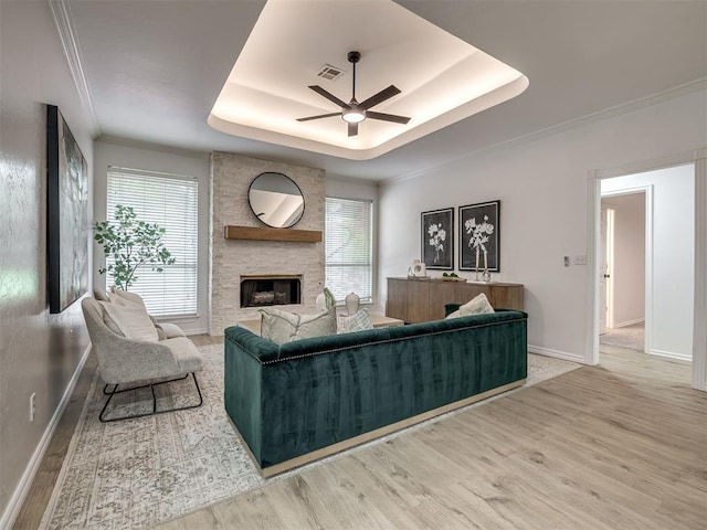 1340 NW 168th St, Edmond, OK 73012 - living area with a raised ceiling, ceiling fan, wood finished floors, a fireplace, and crown molding