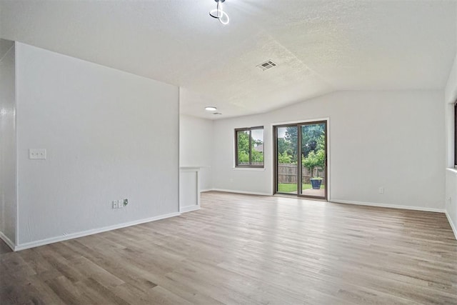 3300 Outpost Cir, Norman, OK 73072 - spare room with wood finished floors, a textured ceiling, and lofted ceiling