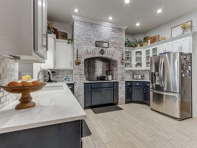 123 E Lakeview Trl, Edmond, OK 73003 - kitchen featuring stainless steel fridge, decorative backsplash, white cabinets, glass insert cabinets, and light stone countertops