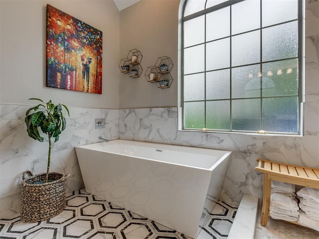 123 E Lakeview Trl, Edmond, OK 73003 - bathroom featuring a soaking tub, tile walls, and a wainscoted wall