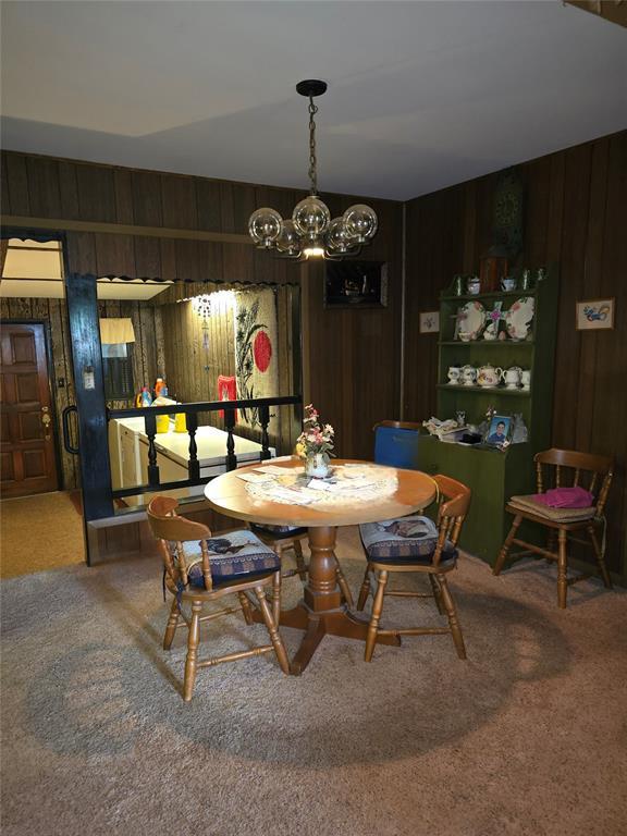 730 N Santa Fe St Unit 4052073333, Pauls Valley, OK 73075 - dining space with carpet, wooden walls, and a chandelier