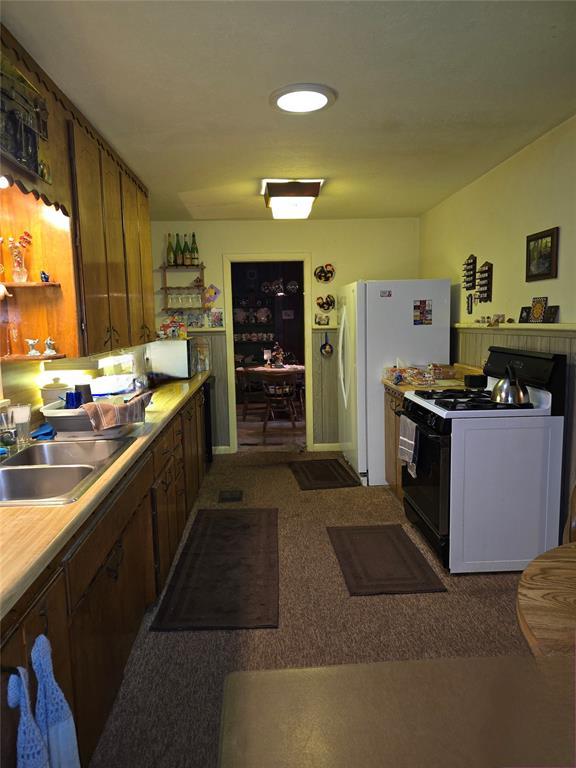 730 N Santa Fe St Unit 4052073333, Pauls Valley, OK 73075 - kitchen with range with gas cooktop, light countertops, and freestanding refrigerator