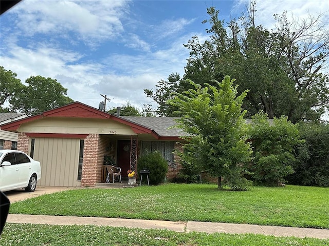 3040 Overland Dr, Del City, OK 73115 - view of front of property featuring brick siding, a front yard, and roof with shingles