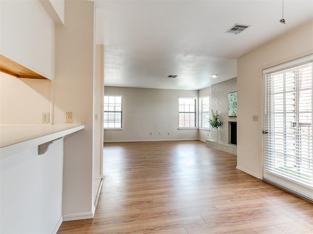 4400 Hemingway Dr Unit 221, Oklahoma City, OK 73118 - unfurnished living room with light wood-type flooring and a fireplace