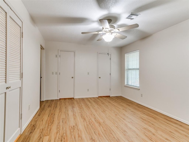 4400 Hemingway Dr Unit 221, Oklahoma City, OK 73118 - unfurnished bedroom featuring light wood-style floors, multiple closets, and ceiling fan