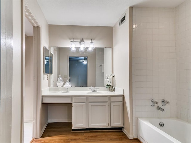 4400 Hemingway Dr Unit 221, Oklahoma City, OK 73118 - bathroom featuring wood finished floors, vanity, and tub / shower combination
