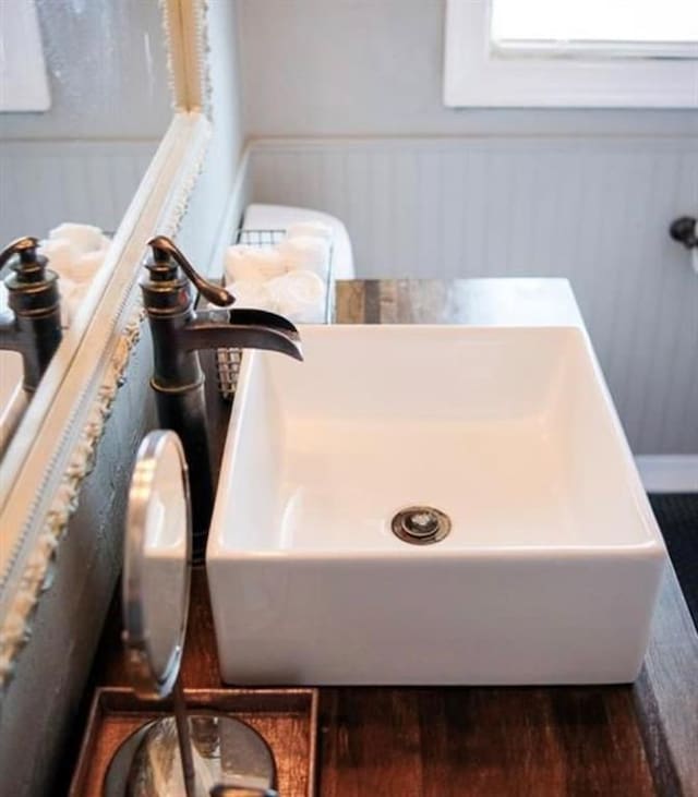 4508 N College Ave, Bethany, OK 73008 - bathroom with a wainscoted wall, wood finished floors, and a bath