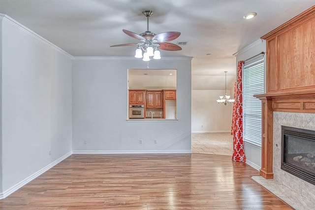 3900 Irvine Dr, Norman, OK 73072 - unfurnished living room featuring ceiling fan, light wood finished floors, a fireplace, a chandelier, and crown molding