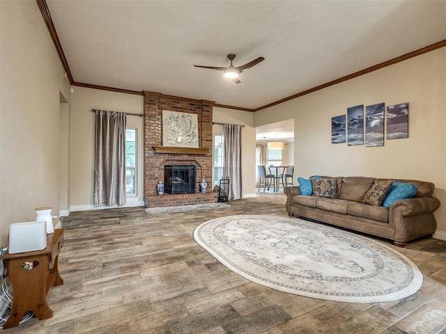 17213 Sunny Hollow Rd, Edmond, OK 73012 - living area with crown molding, a ceiling fan, healthy amount of natural light, wood finished floors, and a brick fireplace