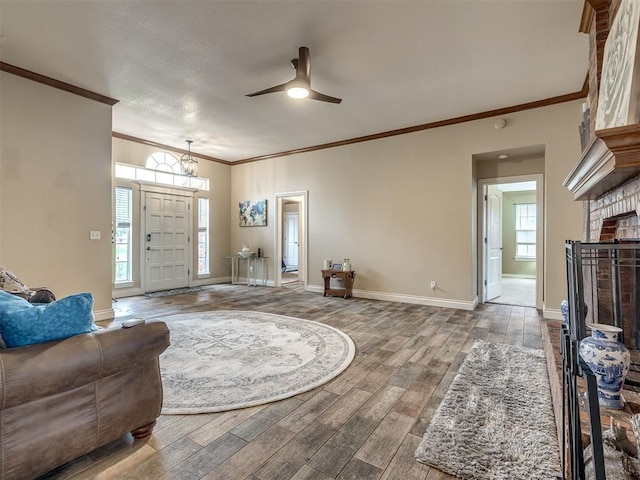 17213 Sunny Hollow Rd, Edmond, OK 73012 - living room with wood finished floors, crown molding, a ceiling fan, and a brick fireplace
