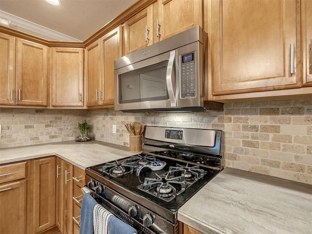 17213 Sunny Hollow Rd, Edmond, OK 73012 - kitchen featuring appliances with stainless steel finishes, light countertops, tasteful backsplash, and brown cabinetry