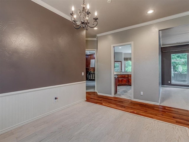 3716 Equestrian Ct, Edmond, OK 73034 - unfurnished room with wood finished floors, a chandelier, ornamental molding, and wainscoting
