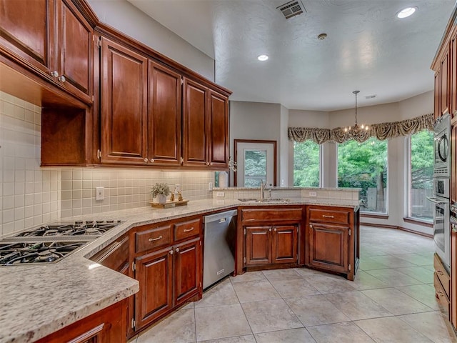 3716 Equestrian Ct, Edmond, OK 73034 - kitchen with appliances with stainless steel finishes, a peninsula, backsplash, a chandelier, and recessed lighting